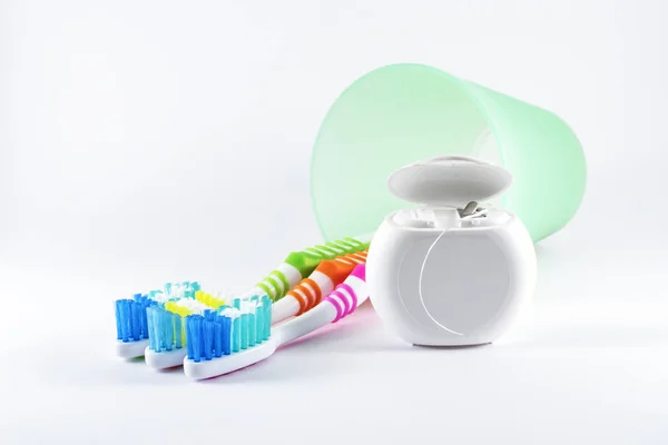 Toothbrushes and dental floss on white background — Stock Photo, Image