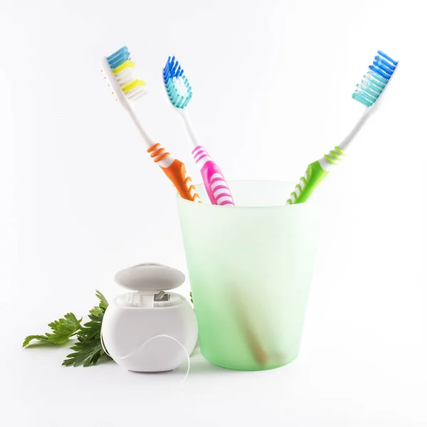 Toothbrushes and dental floss on white background — Stock Photo, Image