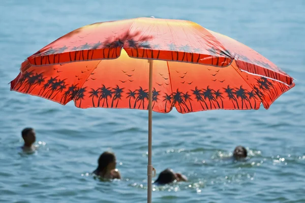 Červený slunečník u moře — Stock fotografie