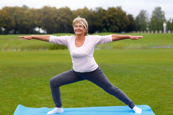 Mujer madura practicando yoga en el parque —  Fotos de Stock