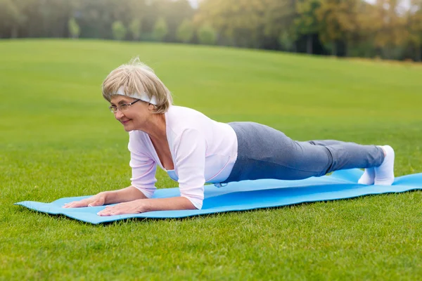 Mujer madura practicando yoga en el parque —  Fotos de Stock