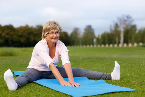 Mujer madura practicando yoga en el parque —  Fotos de Stock