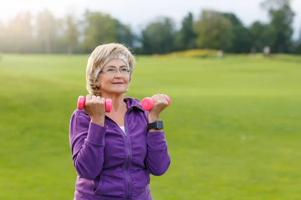 Parkta çalışan olgun bir kadın.
