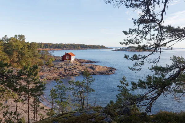 Red and white cottage on a cliff in the archilelago — Stock Photo, Image