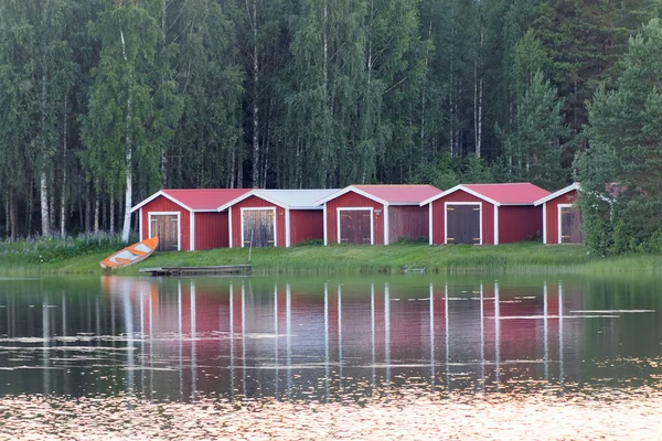 Grupp av röda båthuset vid vattnet — Stockfoto