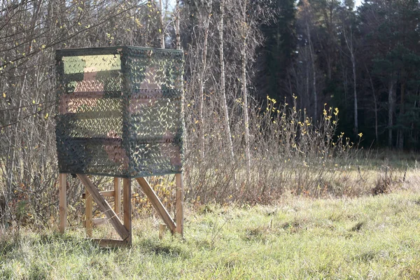 Torre de caza con red de camuflaje en el prado — Foto de Stock