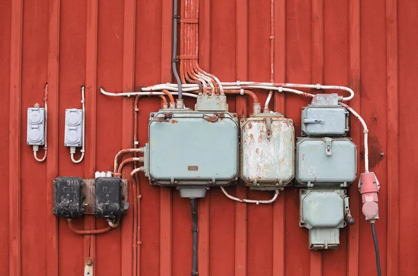 Retro styled junction boxes on a red wall — Stock Photo, Image