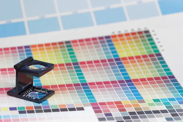 Ampliação ou lupa da impressora fica em uma folha de teste CMYK colorida — Fotografia de Stock