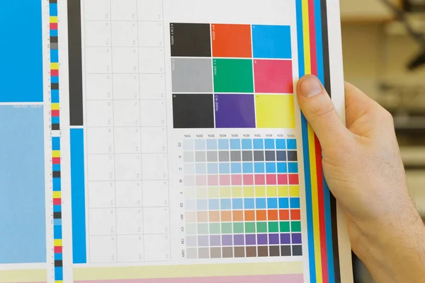 Рука тримає барвистий тестовий принт для перевірки — стокове фото