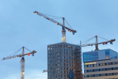 Stockholm - 15 Ocak 2017: Sihouette sarı Vinçler, mavi gökyüzü ve yüksek binalar. 15 Ocak 2017 yılında Hagastaden, Stockholm, İsveç