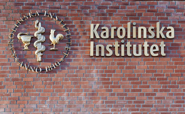 Логотип Каролинского института на кирпичной стене
