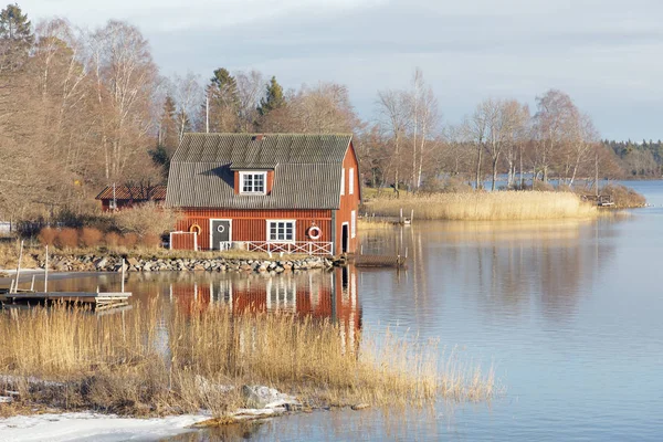 Eski kırmızı tekne ev ve kamış eflecting denizde — Stok fotoğraf