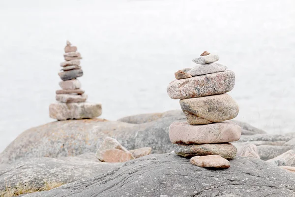 Δύο σωρούς από πέτρες πάνω στο βράχο, η θάλασσα στο παρασκήνιο — Φωτογραφία Αρχείου