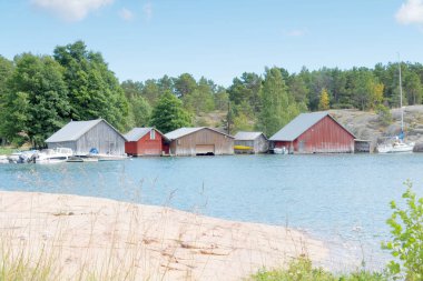 Kırmızı ve gri boathouses, kaya ve ağaçlar