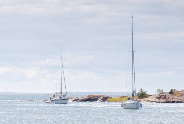 ECKEROE, FINLAND - JUL 14, 2016: Two sailboats on the glittering blue sea a summer day in the archipelago. July 14, 2016 in Eckeroe, Finland