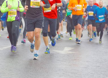 Brighton, İngiltere - 26 Şubat 2017: Vitality Brighton yarı maratonunda ıslak asfalt üzerinde renkli koşu ayakları, bacaklar ve gövdelerin yakın çekimi. 26 Şubat 2017, Brighton, İngiltere