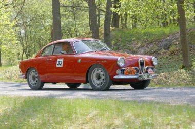 Stockholm, İsveç - 22 Mayıs 2017: 1960 yılından kalma kırmızı Alfa Romeo Guiletta klasik otomobil Curgarden, Stockholm, İsveç 'teki ormanlarda Gardesloppet halk yarışında bir kır yolunda sürüyordu. 22 Mayıs 2017