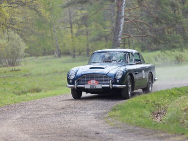 Stockholm, İsveç - 22 Mayıs 2017: 1965 sürüş ormanlarında Gardesloppet genel yarış bir ülkede yol Djurgarden, Stokholm, İsveç gelen siyah bir Aston Martin salon klasik araba. 22 Mayıs 2017