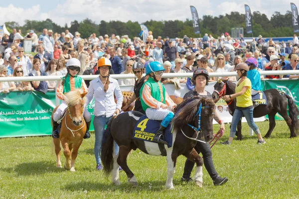 Stockholm, İsveç - Haziran 06, 2017: Genç jokeyler Gardet 'deki Nationaldags Galoppen kasasında midilli yarışı atları ısıtıyorlar. 6 Haziran 2017 Stockholm, İsveç
