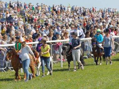 Genç jockeys midilli dörtnala yarış atları kadar Isınma