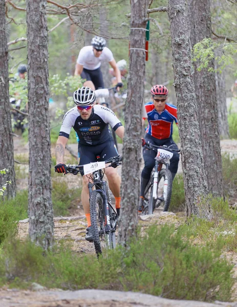 Group of male mountain bike cyclists in the forest partly hidden