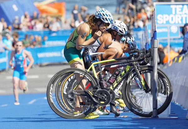 Stockholm - 26 Ağustos 2017: Kadın triatlet Ashleigh Gentle (Aus) ve Andrea Hewitt (Nzl), 26 Ağustos 2017 'de İsveç' in Stockholm kentinde düzenlenen Dünya Kadınlar Triatlon Şampiyonası 'nda geçiş bölgesinde kask takıyorlar.