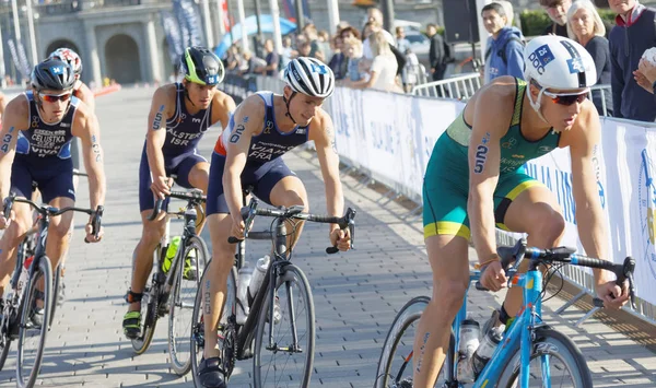 Grupp manliga triathlet cyklister i en kurva — Stockfoto