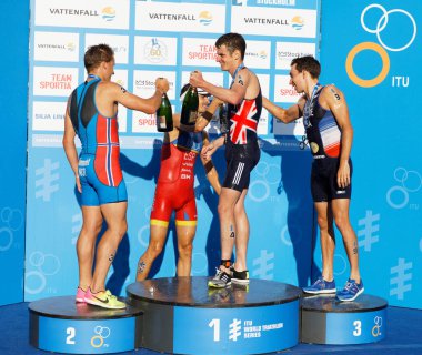 Stockholm - 26 Ağustos 2017: Jonathan Brownlee, Kristian Blummenfelt ve Pierre le Corre kazananın stand erkekler İTÜ dünya triatlon serisi olay Augist 26, 2017 Stokholm, İsveç, şampanya içiyor