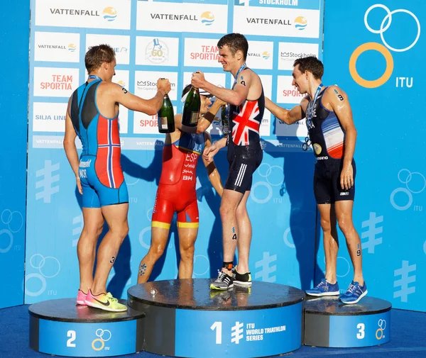 Stockholm - 26 Ağustos 2017: Jonathan Brownlee, Kristian Blummenfelt ve Pierre le Corre kazananın stand erkekler İTÜ dünya triatlon serisi olay Augist 26, 2017 Stokholm, İsveç, şampanya içiyor