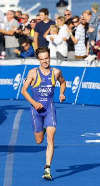Stockholm - 26 Ağustos 2017: Finiş çizgisine yakın koşan triatlet Gabriel Sandor (Swe), 26 Ağustos 2017 'de Stockholm, İsveç' te düzenlenen Erkekler Itu Dünya Triatlon Serisi 'nin arka planında seyirci
