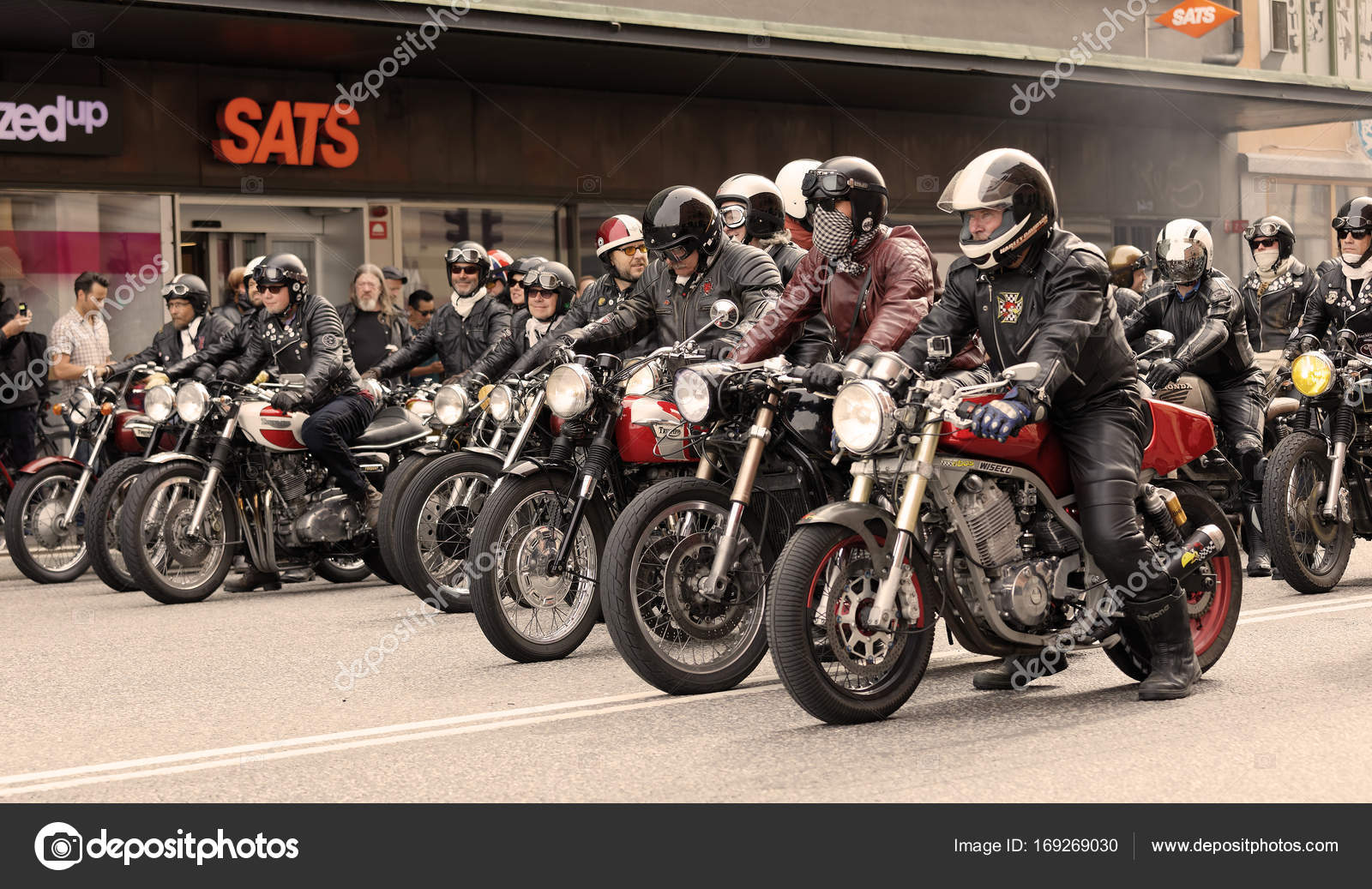 Tough mc drivers in leather clothes on retro motorcycles side by