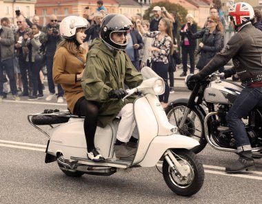 Stockholm, İsveç - Eylül 02, 2017: Eski moda Vespa scooter kullanan erkek ve kadın mod 'lar Saint Eriks Köprüsü, Stockholm, İsveç' te eski moda Vespa scooter 'lar.