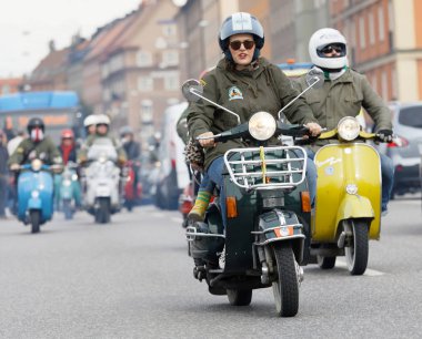 STOCKHOLM, SWEDEN - SEPT 02, 2017: Closeup of female mods wearing old fashioned clothes driving beautiful old fashioned vespa scooter at the Mods vs Rockers event at the Saint Eriks bridge, Stockholm, Sweden, September 02, 2017