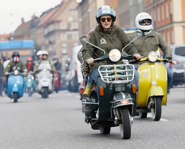 STOCKHOLM, SWEDEN - SEPT 02, 2017: Closeup of female mods wearing old fashioned clothes driving beautiful old fashioned vespa scooter at the Mods vs Rockers event at the Saint Eriks bridge, Stockholm, Sweden, September 02, 2017