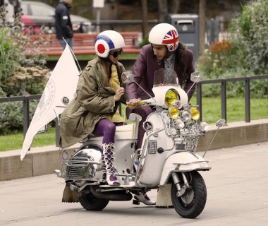 Stockholm, İsveç - Eylül 02, 2017: Genç çift, Mods vs Rockers 'ın Saint Eriks Köprüsü, Stockholm, İsveç, 02 Eylül 2017' deki retro vespa scooter 'ında 1960' lardan kalma giysiler giyerek yoldan çıkarıldı.