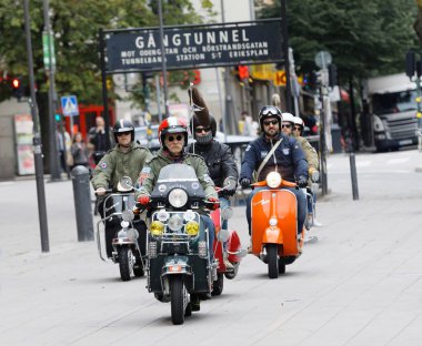 Stockholm, İsveç - Eylül 02, 2017: 1960 'lardan kalma giysiler içinde eski moda Vespa scooter' la Saint Eriks Köprüsü, Stockholm, İsveç 'te düzenlenen eski moda Vespa scooter yarışmasında
