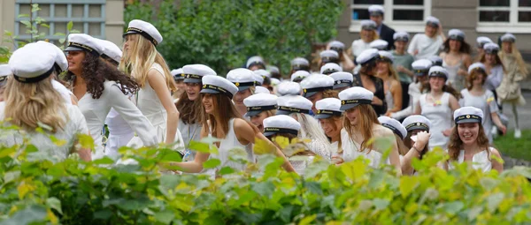 Estudiantes sonrientes con gorras blancas de graduación después de la graduación —  Fotos de Stock