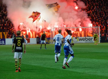 Solna İsveç - 30 Ekim 2017: Aik ve Ifk Gotebork takımlarından futbol oyuncuları, Aik futbol takımının taraftarları ellerinde bayraklar sallayarak kırmızı ateş yakarak çok fazla duman çıkardılar. 30 Ekim 2017, Solna, İsveç