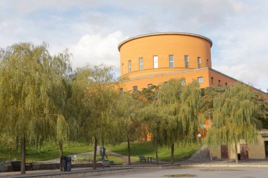 Stockholm, 30 Ekim 2017 Stockholm 'deki ünlü şehir kütüphanesi Stadsbiblioteket, ön plandaki ağaçlar. 30 Ekim 2017, Stockholm, İsveç.