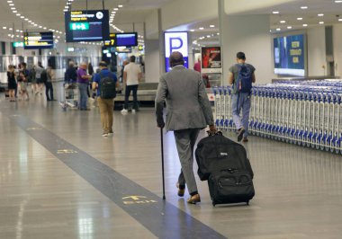 Stockholm, İsveç - 19 Haziran 2017: Arlanda havaalanındaki çıkış salonunda bavul taşıyan yolcular. 19 Haziran 2017 Stockholm, İsveç
