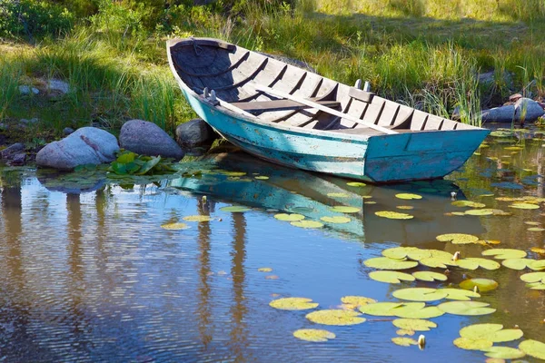 Velho barco a remos de madeira pintado na cor verde wethered amarrado. Wate... — Fotografia de Stock