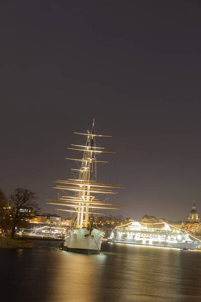 STOCKHOLM, SWEDEN - DEC 27, 2017: Nightscape of the beautiful sailing ship and hotel Af Chapman in central Stockholm in Sweden, December 27, 2017