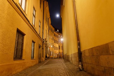 Gece boyunca tarihi kent merkezi Stockholm dar sokakta. Sıcak sarı renkler