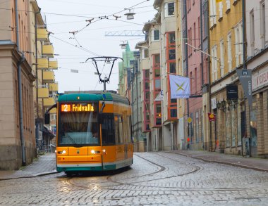 Norrkoping, İsveç - 01 Jan 2018: Sarı tramvay merkezi Norrkoping İsveç, 01 Ocak 2018 yılında ıslak Arnavut kaldırımı Tarih