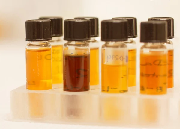 Botellas pequeñas con líquido amarillo utilizadas en el laboratorio para experimentos —  Fotos de Stock