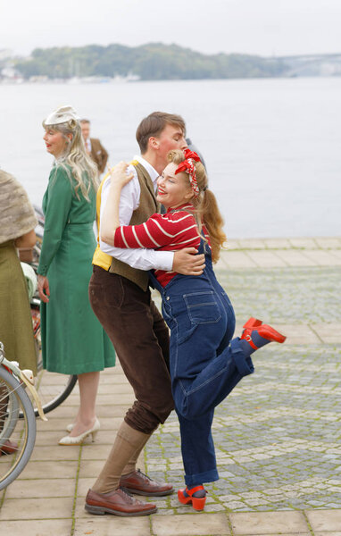 STOCKHOLM - SEPT 23, 2017: Dancing girl and boy dressed in clothes from the 1950s, The girl wearing blue bib and red sweater in the Bike in Tweed event September 23, 2017 in Stockholm, Sweden