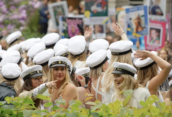 Étudiants souriants portant des casquettes de graduation blanches après l'obtention du diplôme — Photo