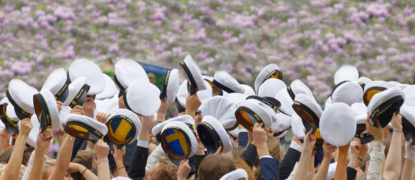 Счастливые шведские выпускники в красивом парке с лилаками
