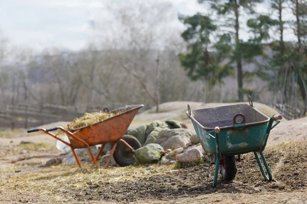 Twee kruiwagen gebruikt voor het verzamelen van stro in het weiland waar de l — Stockfoto