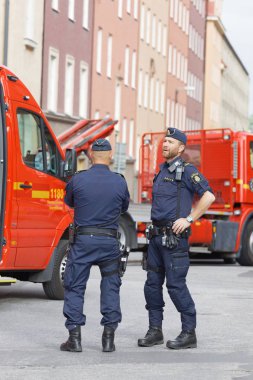 Stockholm, İsveç - 08 Haziran 2017: İsveç polis memuru önünde bir itfaiye araçları Stokholm, İsveç, 08 Haziran 2017 çalışma